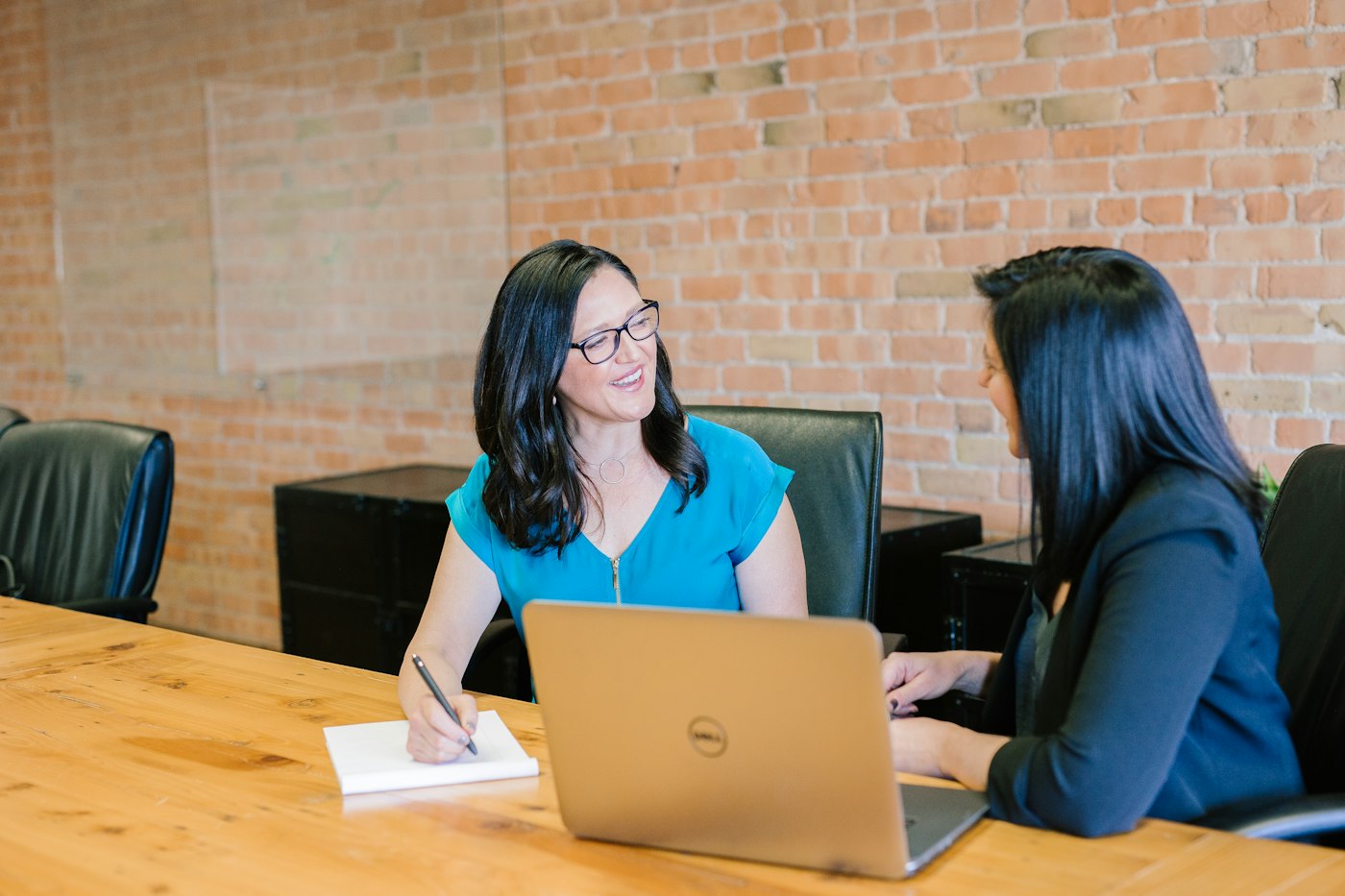 Two people talking through a business over a laptop