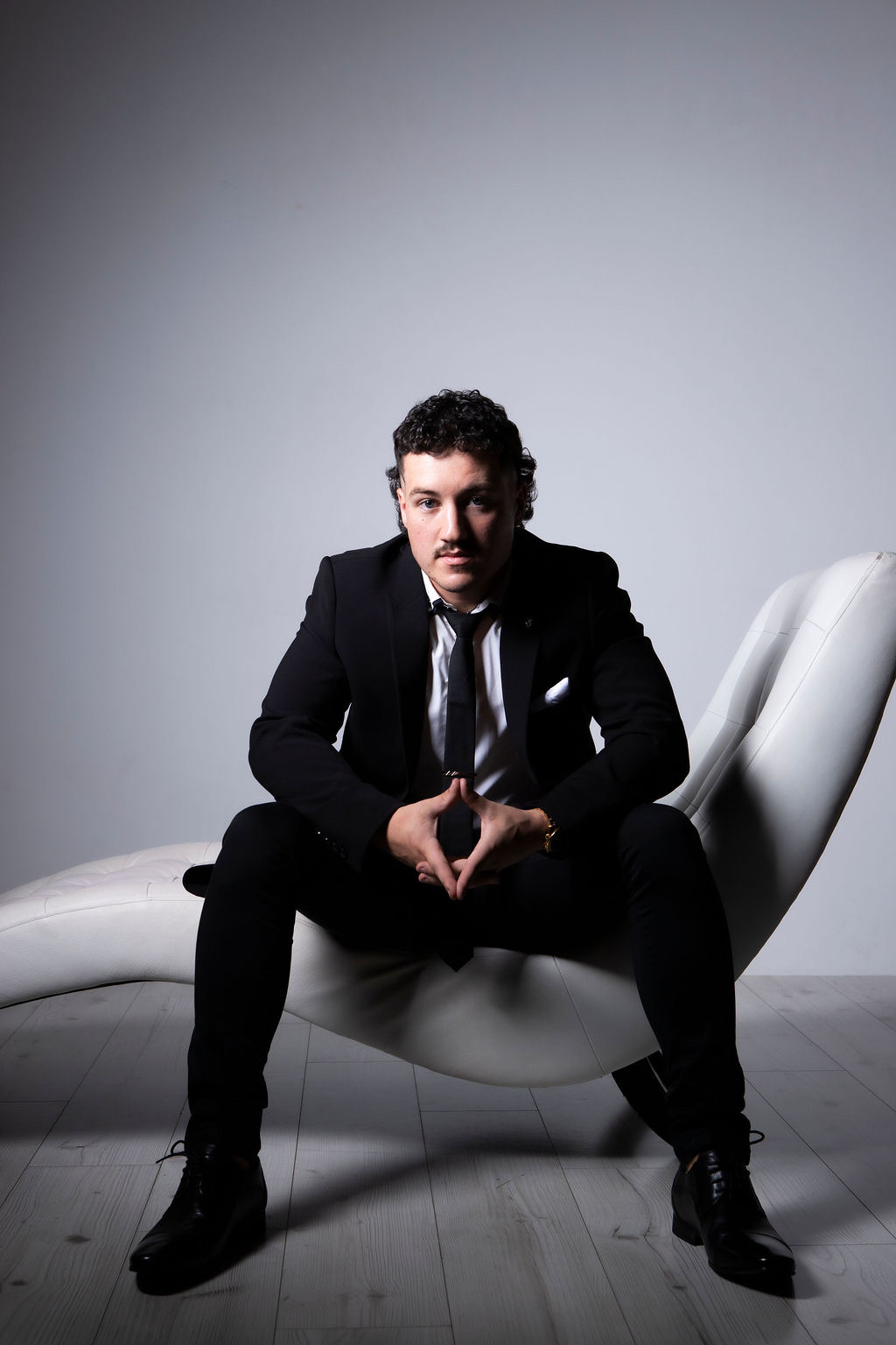 Zack, co-founder, seated in a black suit